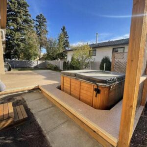 Custom waterproof deck with hot tub and brown Flexstone coating built by CBS Alberta in Edmonton